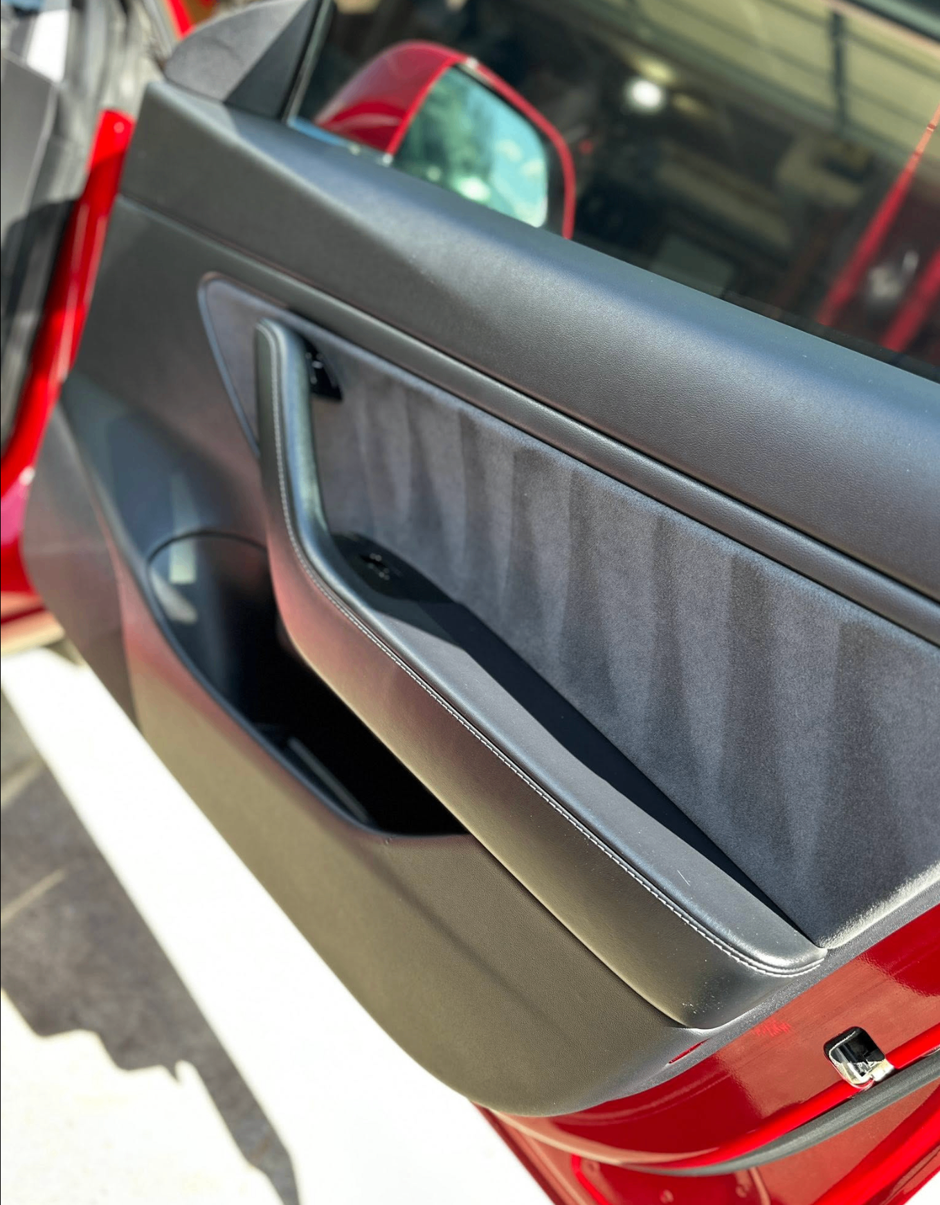 Door panel and trim detail on a red Tesla